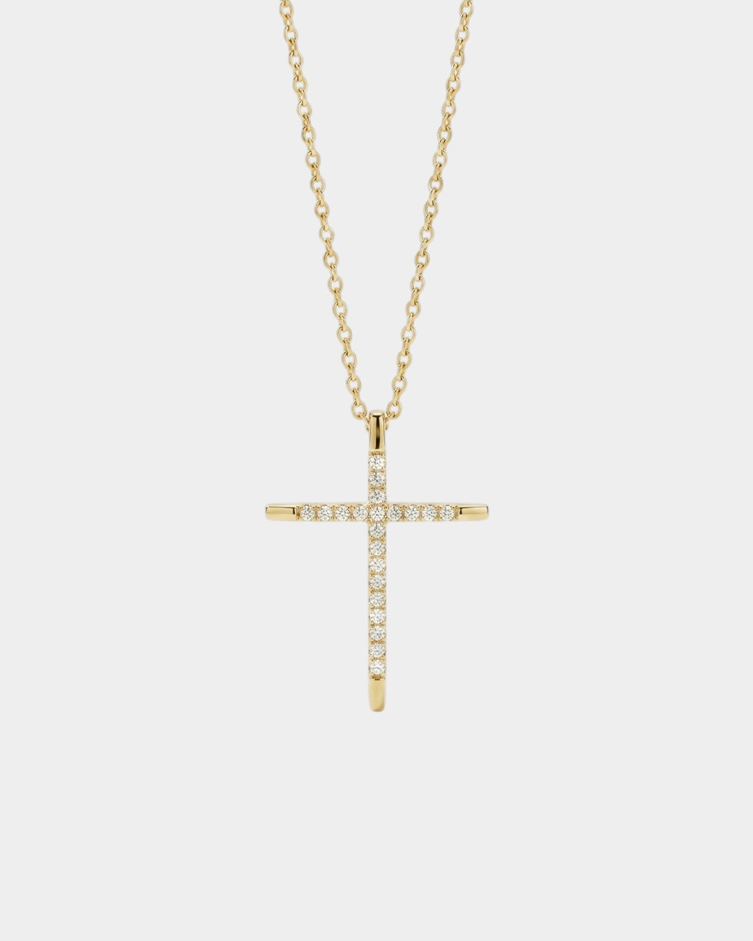 Gold cross necklace with diamonds on a white background