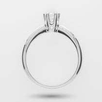 White gold engagement ring with a diamond on a high-profile over a light gray background