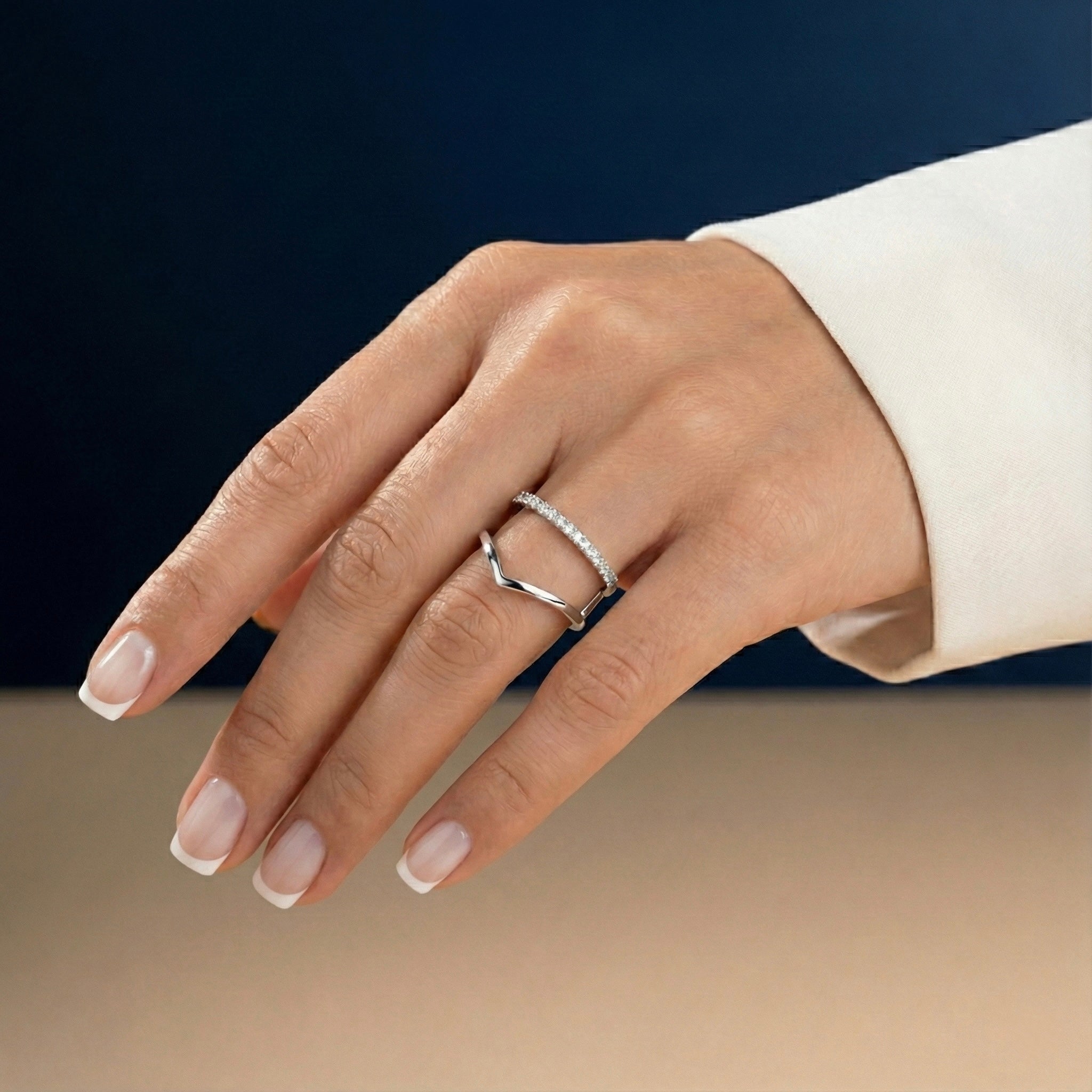 Hand wearing a white gold ring with a dark background