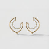 Gold hoop earrings with embedded stones on a light gray background