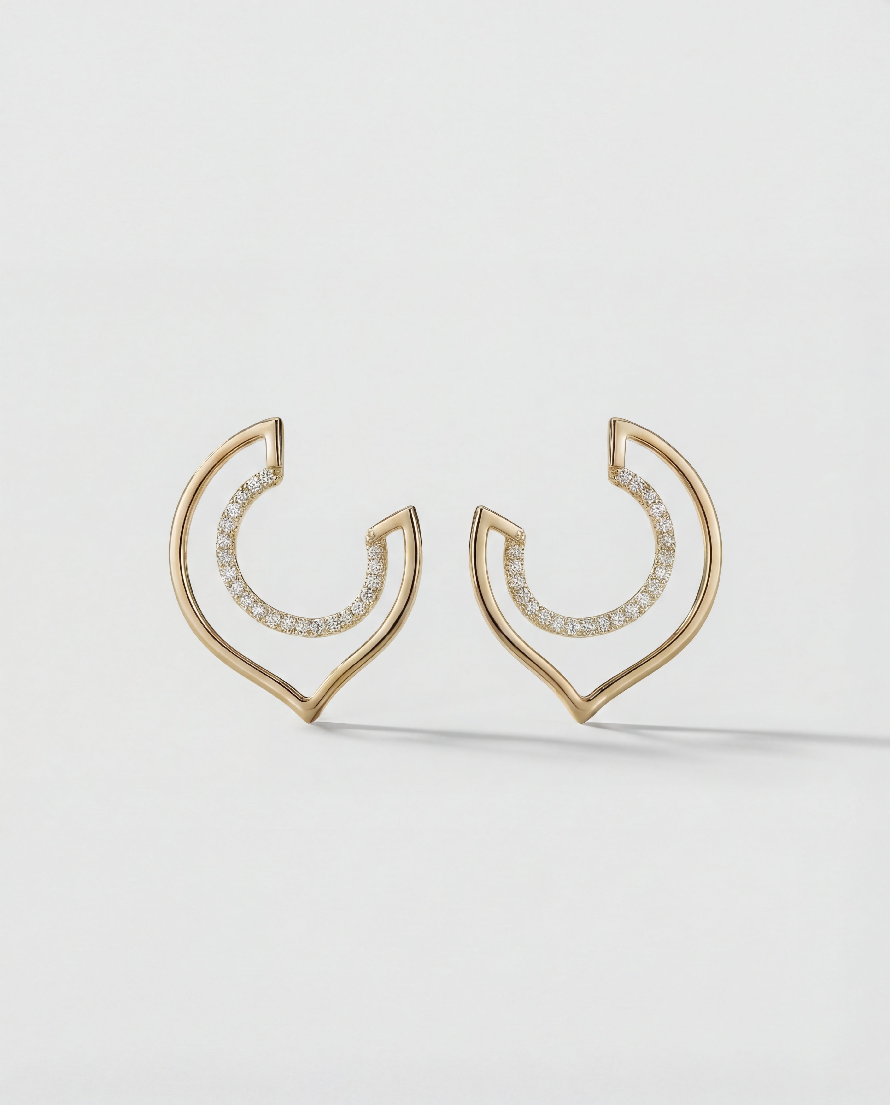 Gold hoop earrings with embedded stones on a light gray background