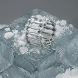White gold ring on a block of ice with a gray background