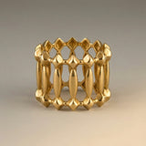 Gold ring with geometric design on a beige background