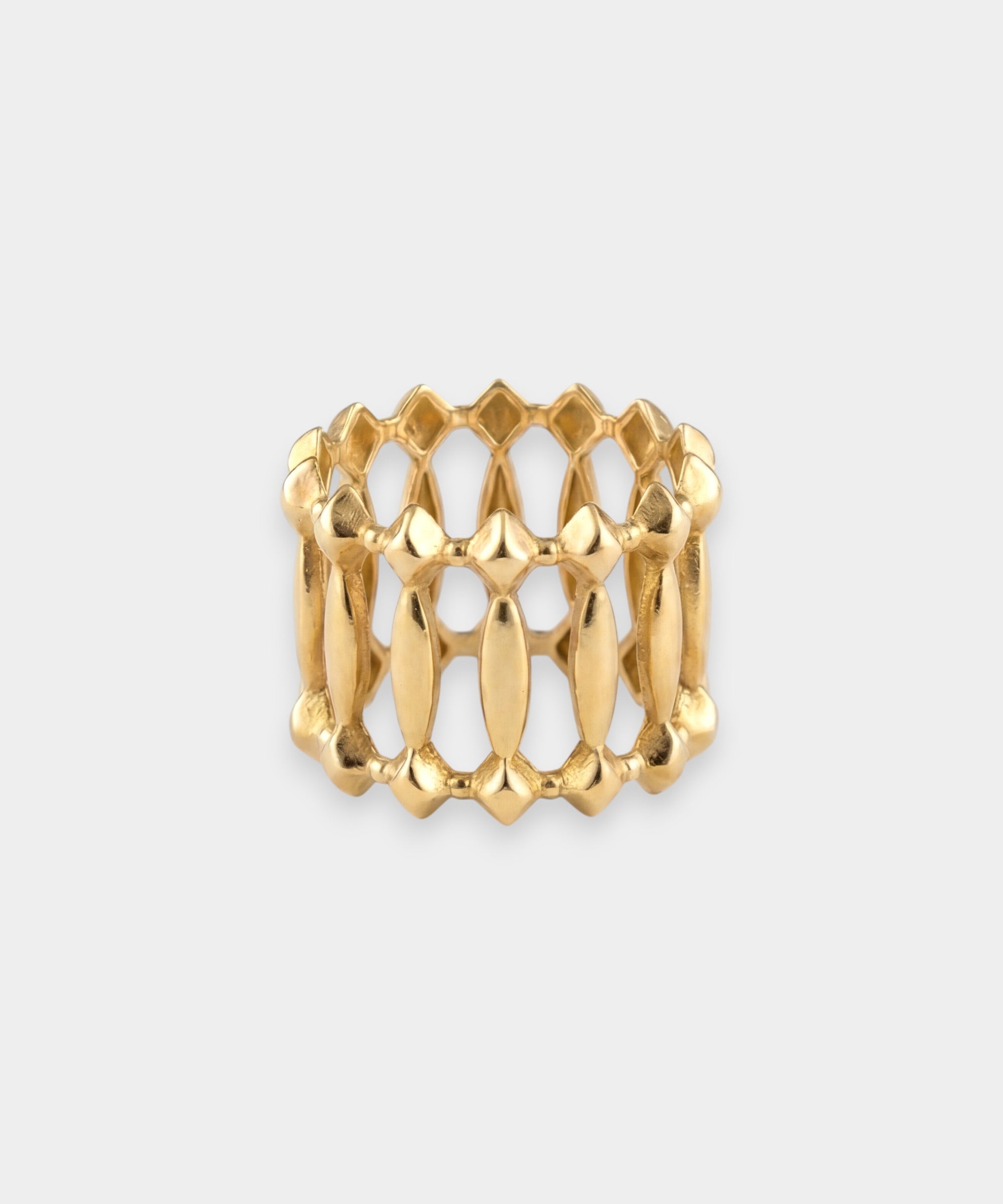 Gold ring with a textured design on a light gray background