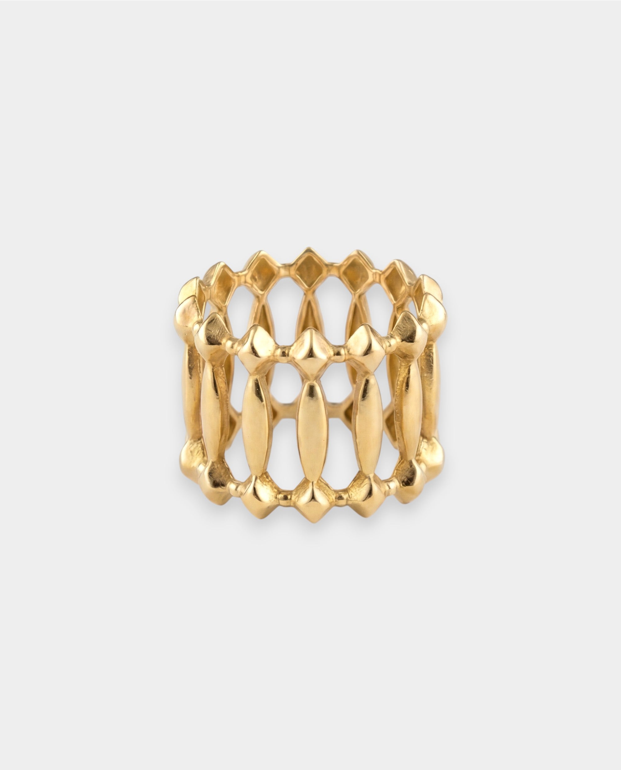 Gold ring with a textured design on a light gray background