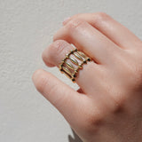 Gold ring with architectural structure on a neutral background