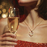 Woman holding a glass of champagne wearing a necklace with a blurred background