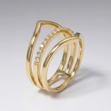 Gold ring with diamond accents on a light gray background