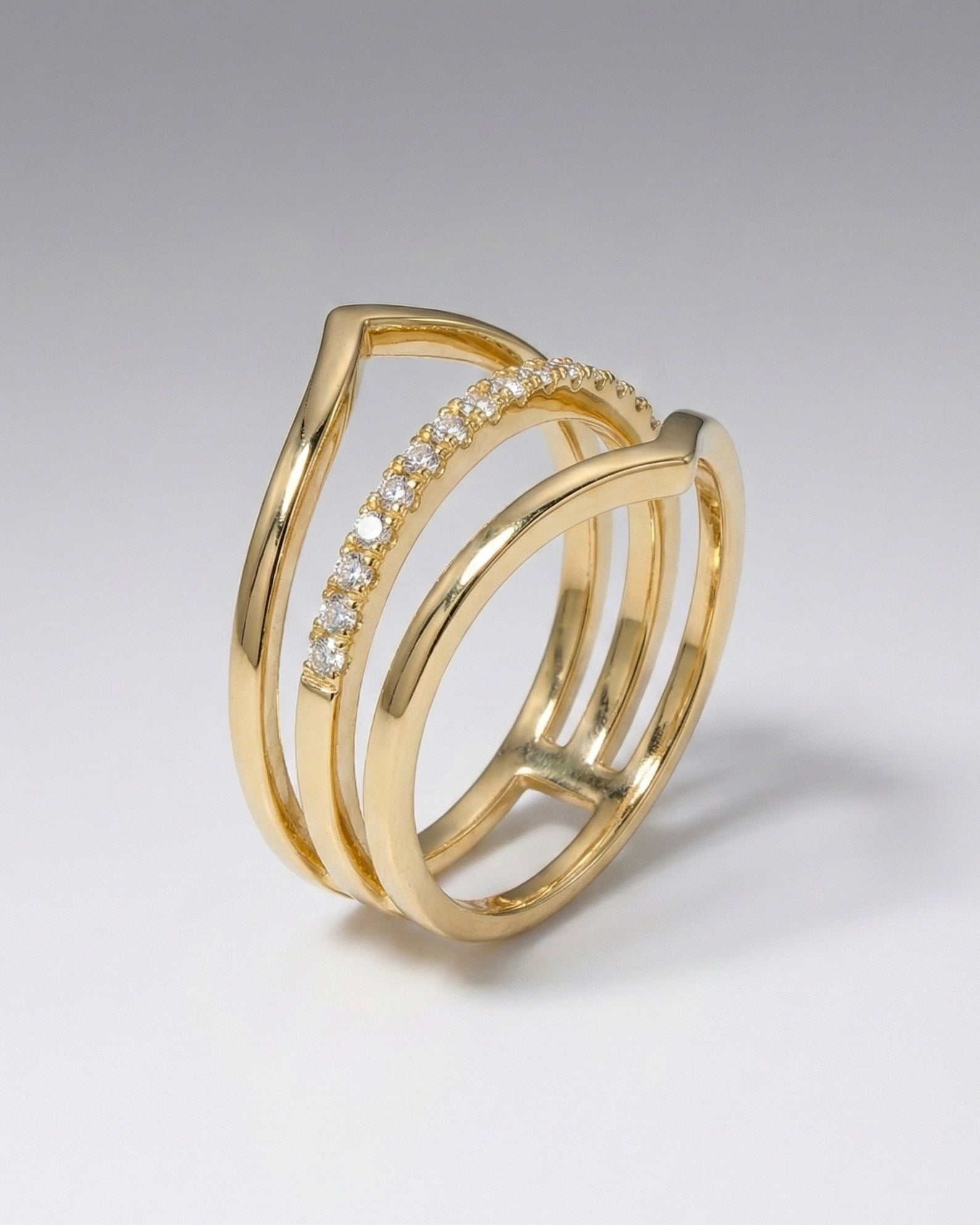 Gold ring with diamond accents on a light gray background