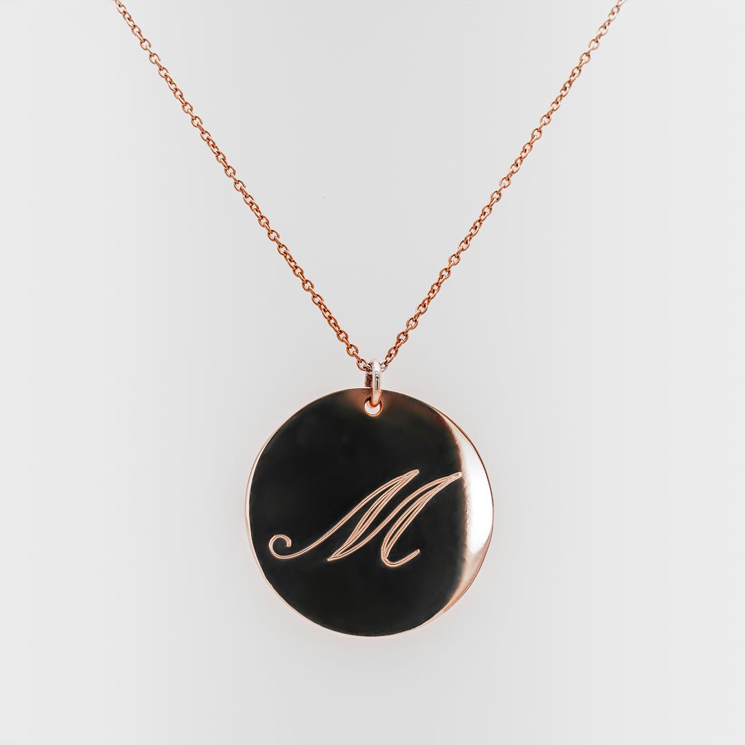 Necklace with a rose-gold pendant featuring the letter 'M' on a white background