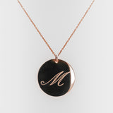 Necklace with a rose-gold pendant featuring the letter 'M' on a white background