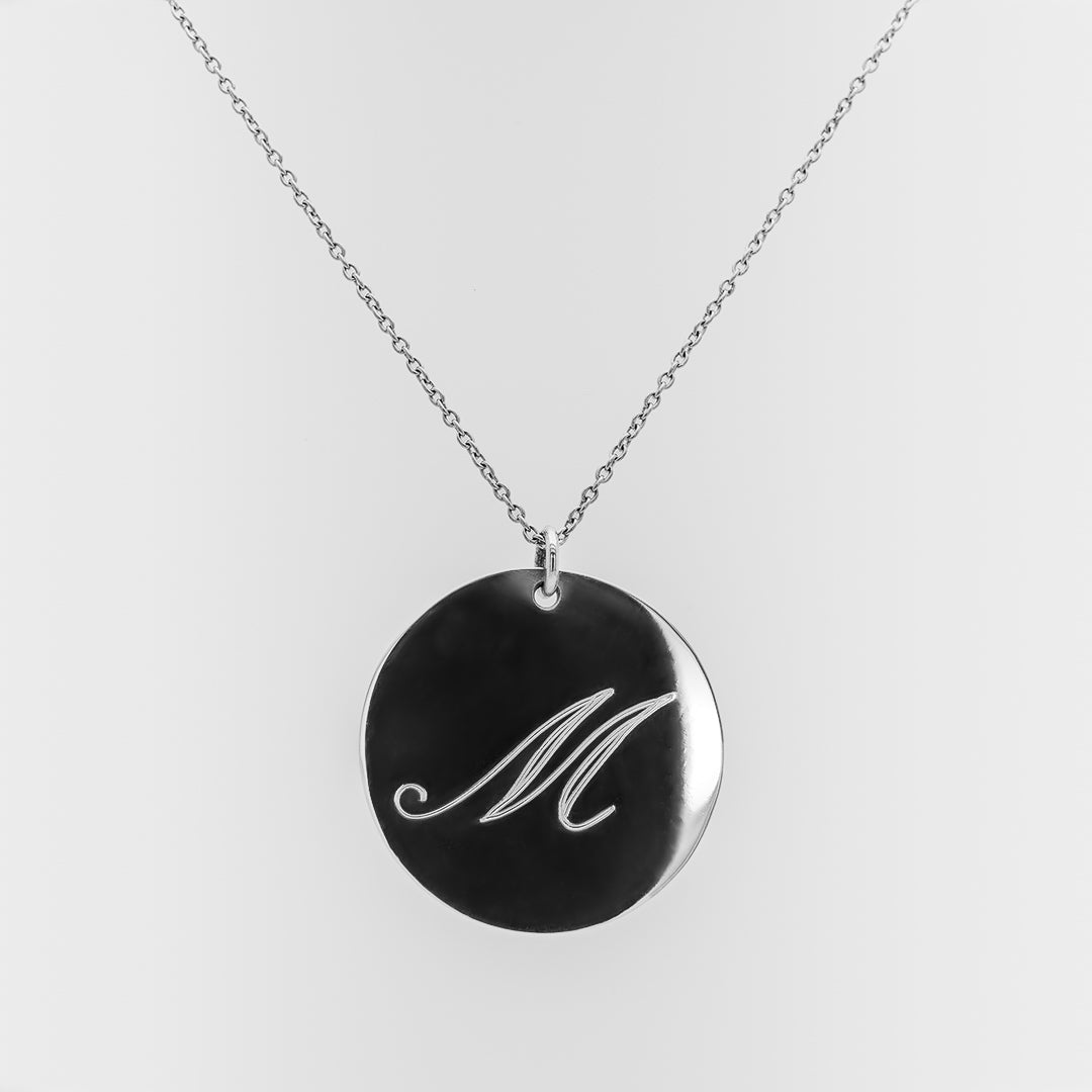 Necklace with a round pendant featuring the letter 'M' on a white background