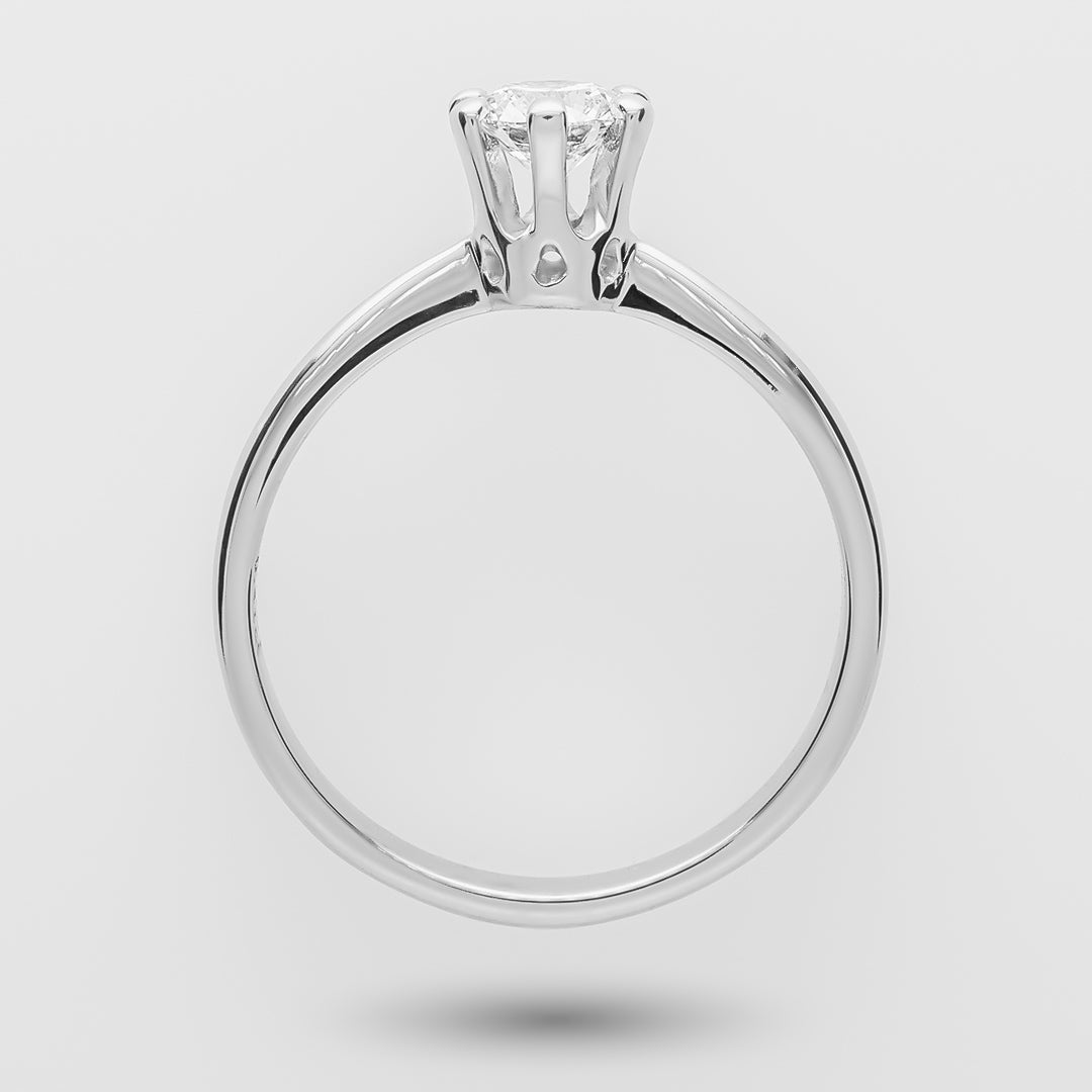 White gold ring with a diamond on a light gray background