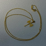 Gold necklace with a unique double-axe pendant on a light gray background