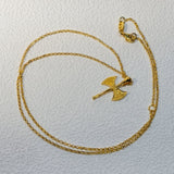 Gold necklace with a unique pendant on a light gray background