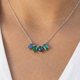 Necklace with green and blue mixed-shape gemstones worn by a person