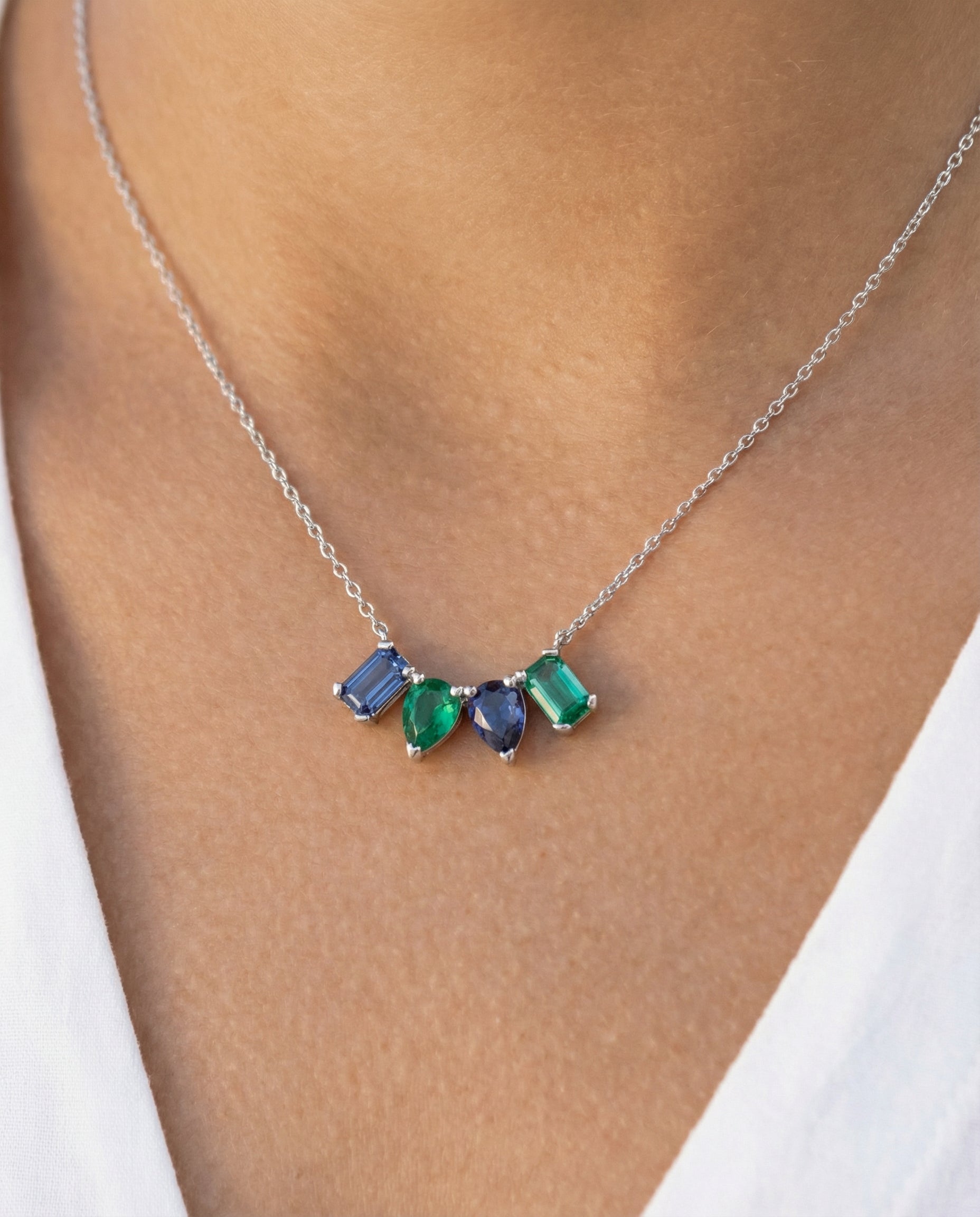Necklace with green and blue mixed-shape gemstones worn by a person