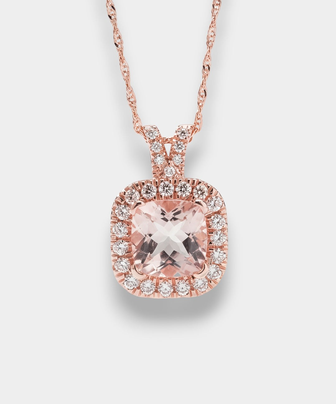 Rose gold necklace with a pink gemstone pendant on a light gray background