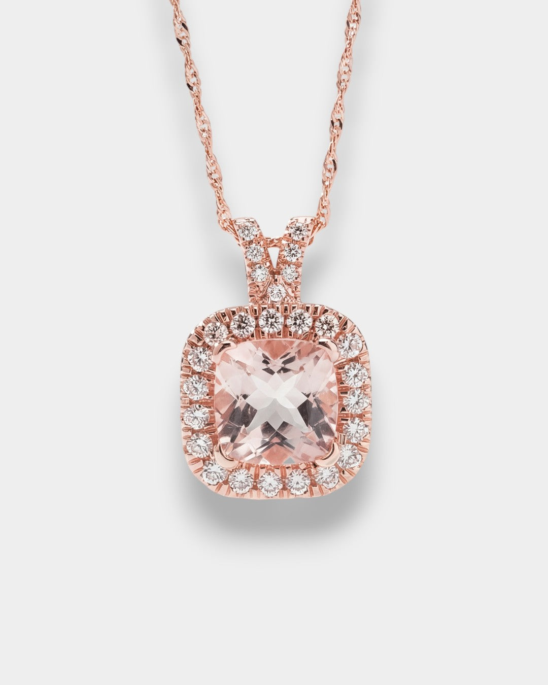 Rose gold necklace with a pink gemstone pendant on a light gray background