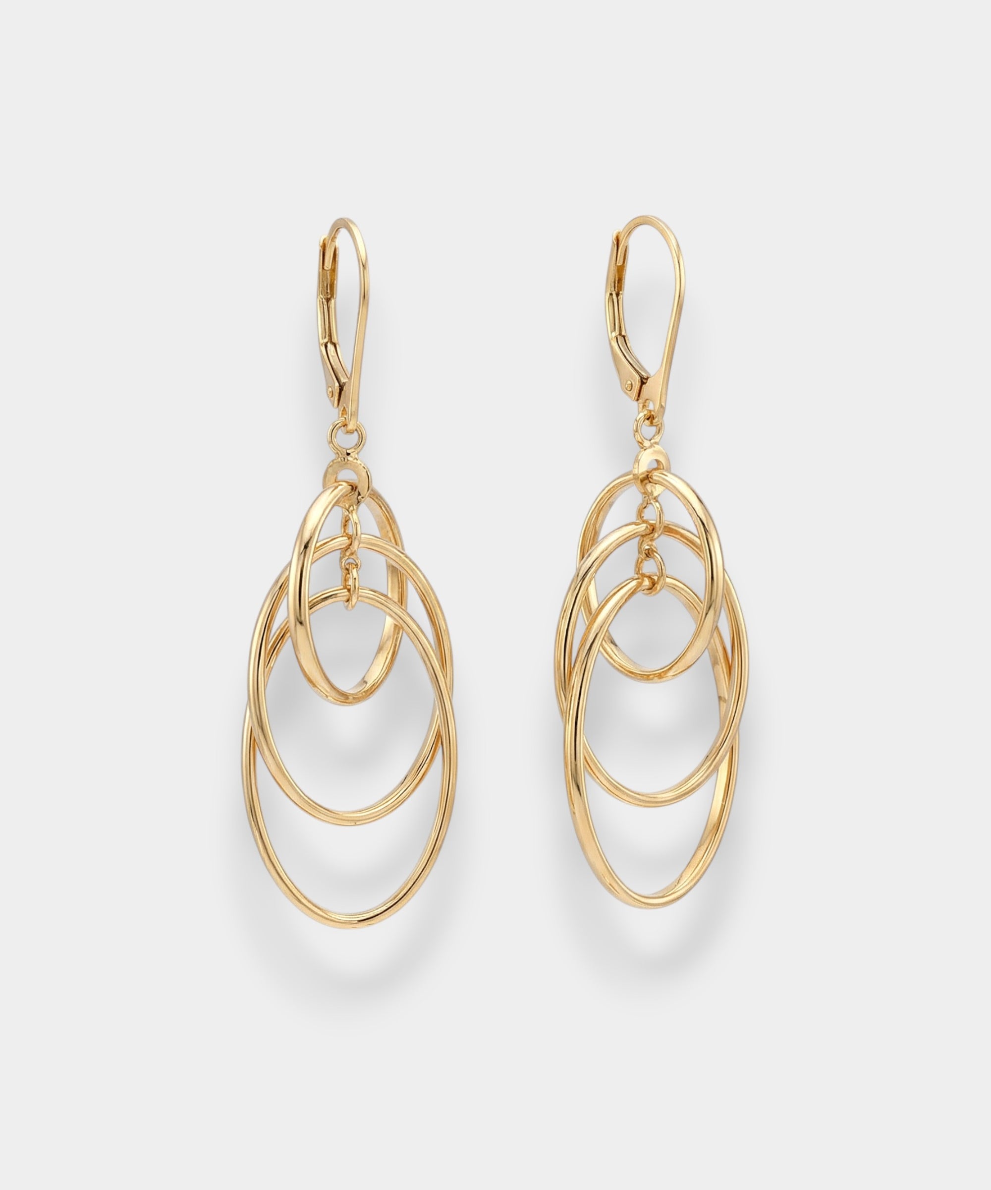 Gold oval hoop earrings on a light gray background