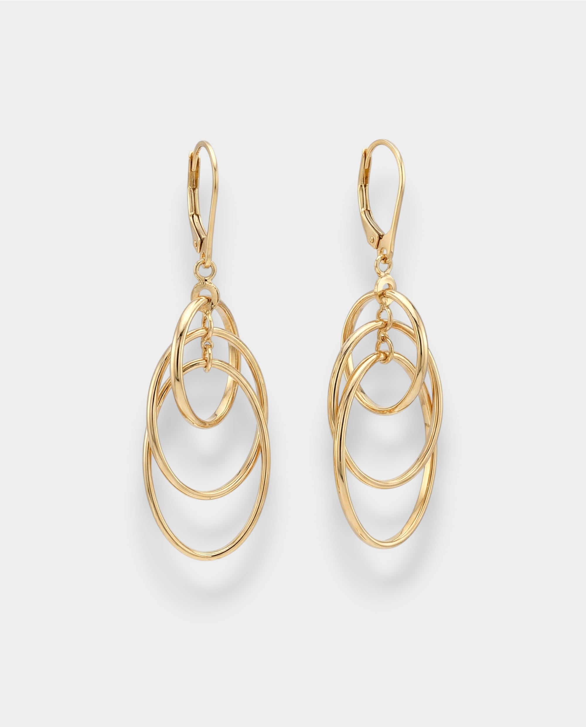 Gold oval hoop earrings on a light gray background