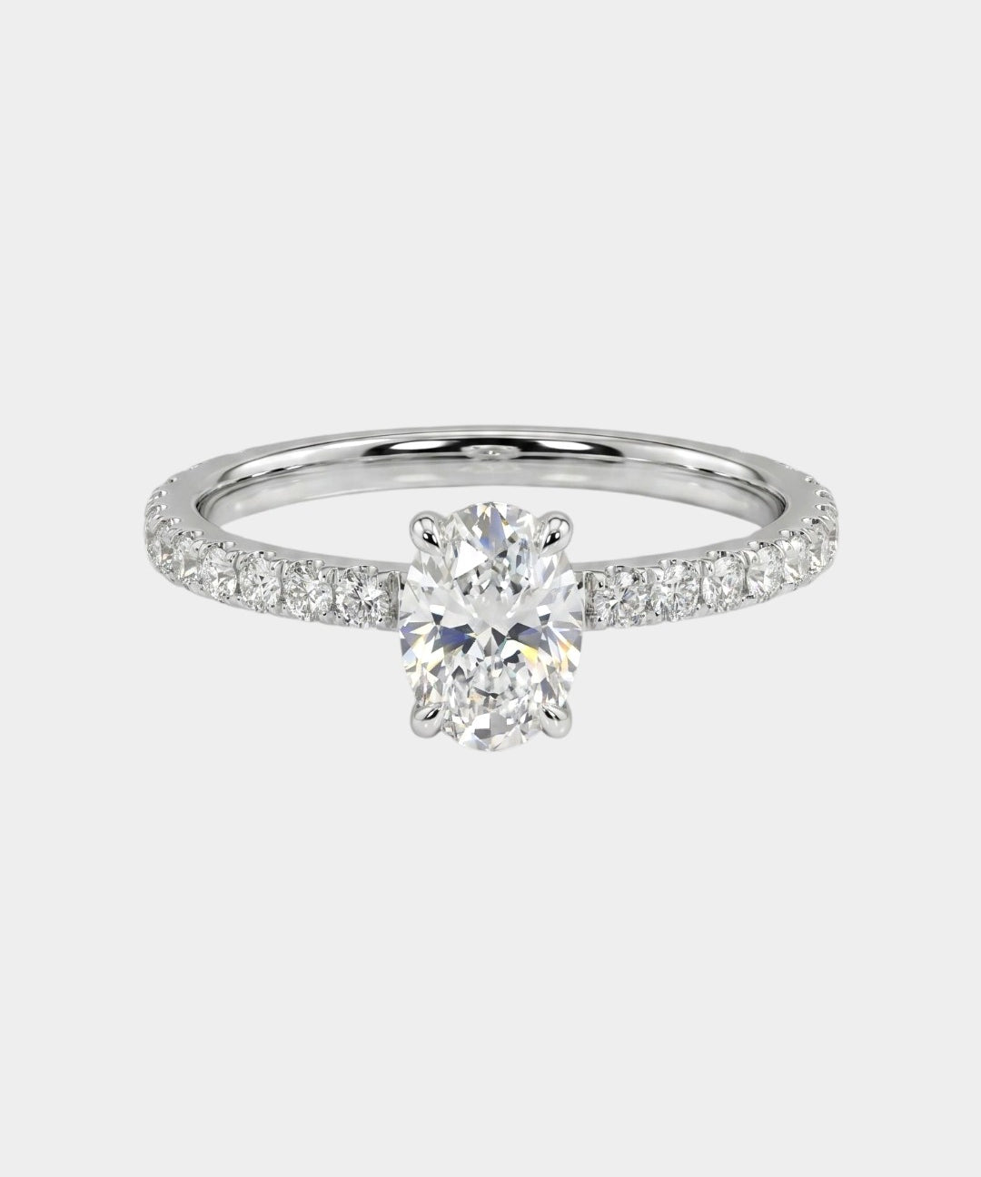 Oval-cut engagement ring with pave diamonds. 