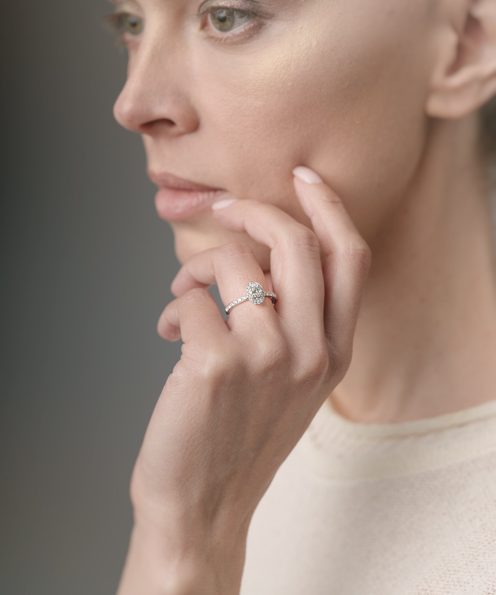 Woman wearing a ring on her finger against a neutral background