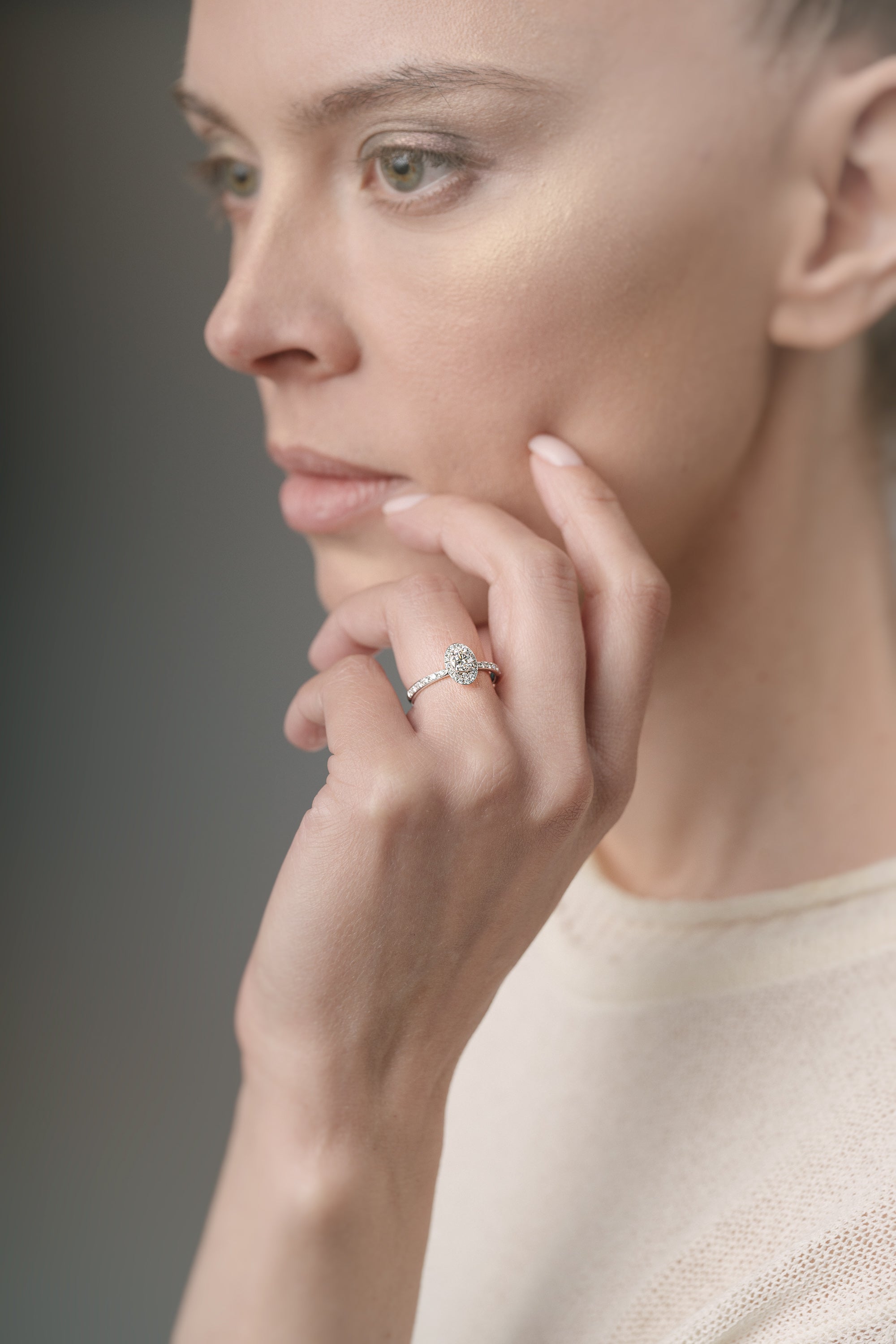 Woman wearing a ring on her finger against a neutral background