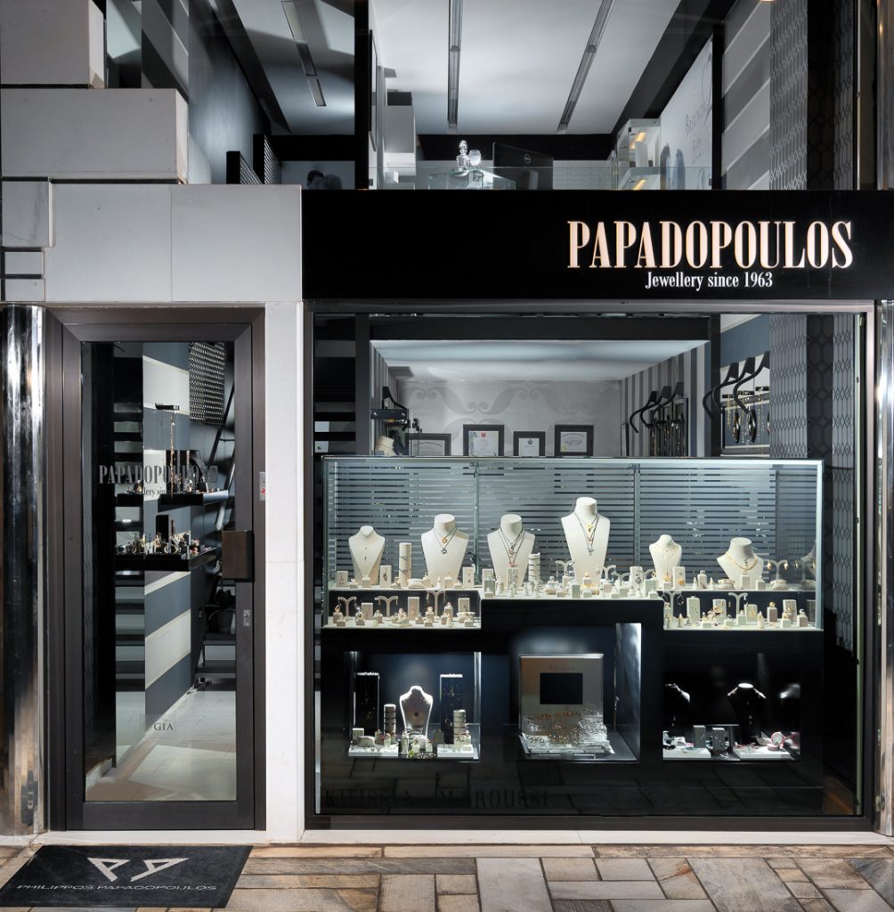 Jewelry store entrance with 'Papadopoulos' sign and display of jewelry.
