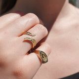 Close-up of a hand wearing two gold rings with special greek designs.