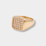 Gold ring with diamond accents on a light gray background