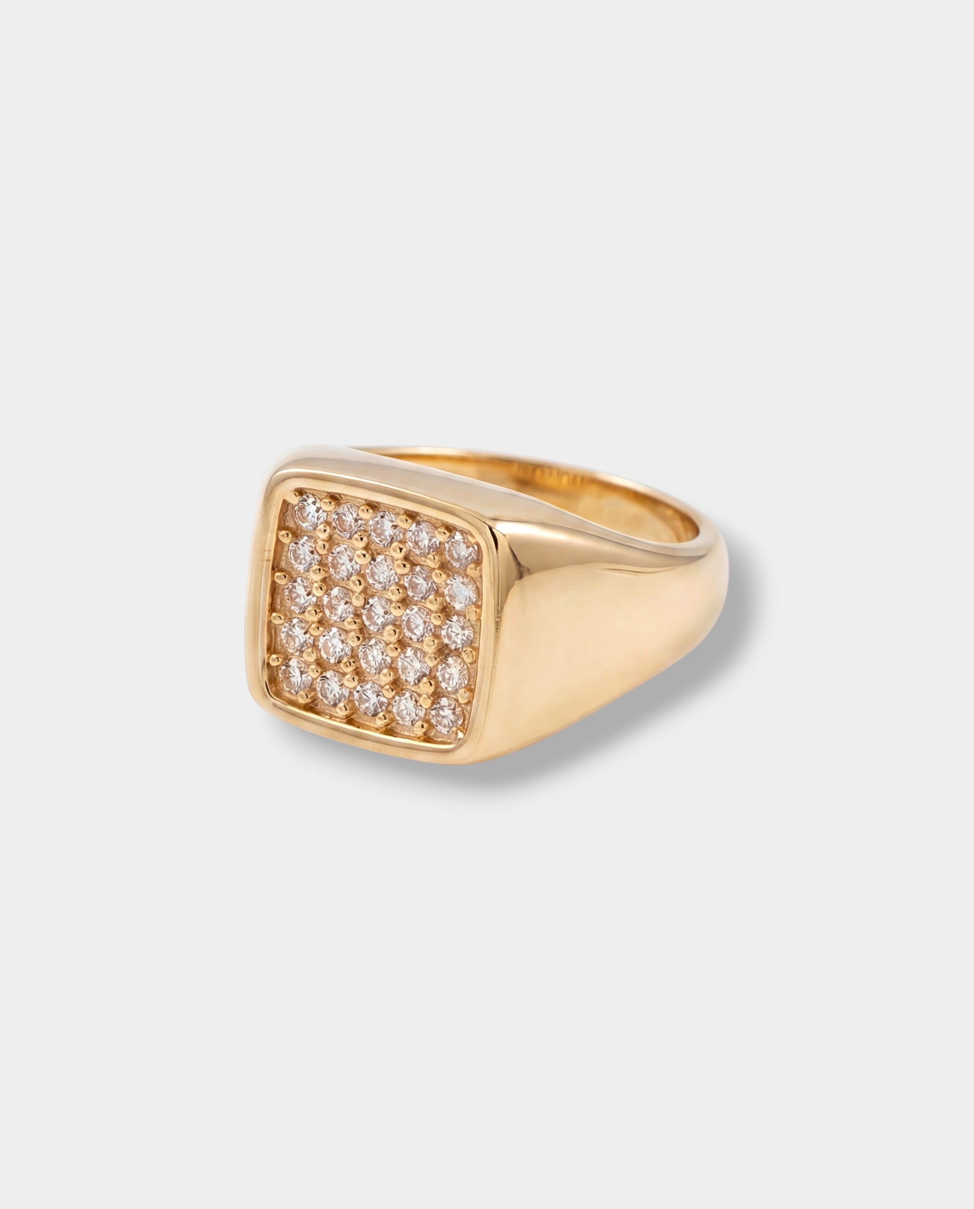 Gold ring with diamond accents on a light gray background