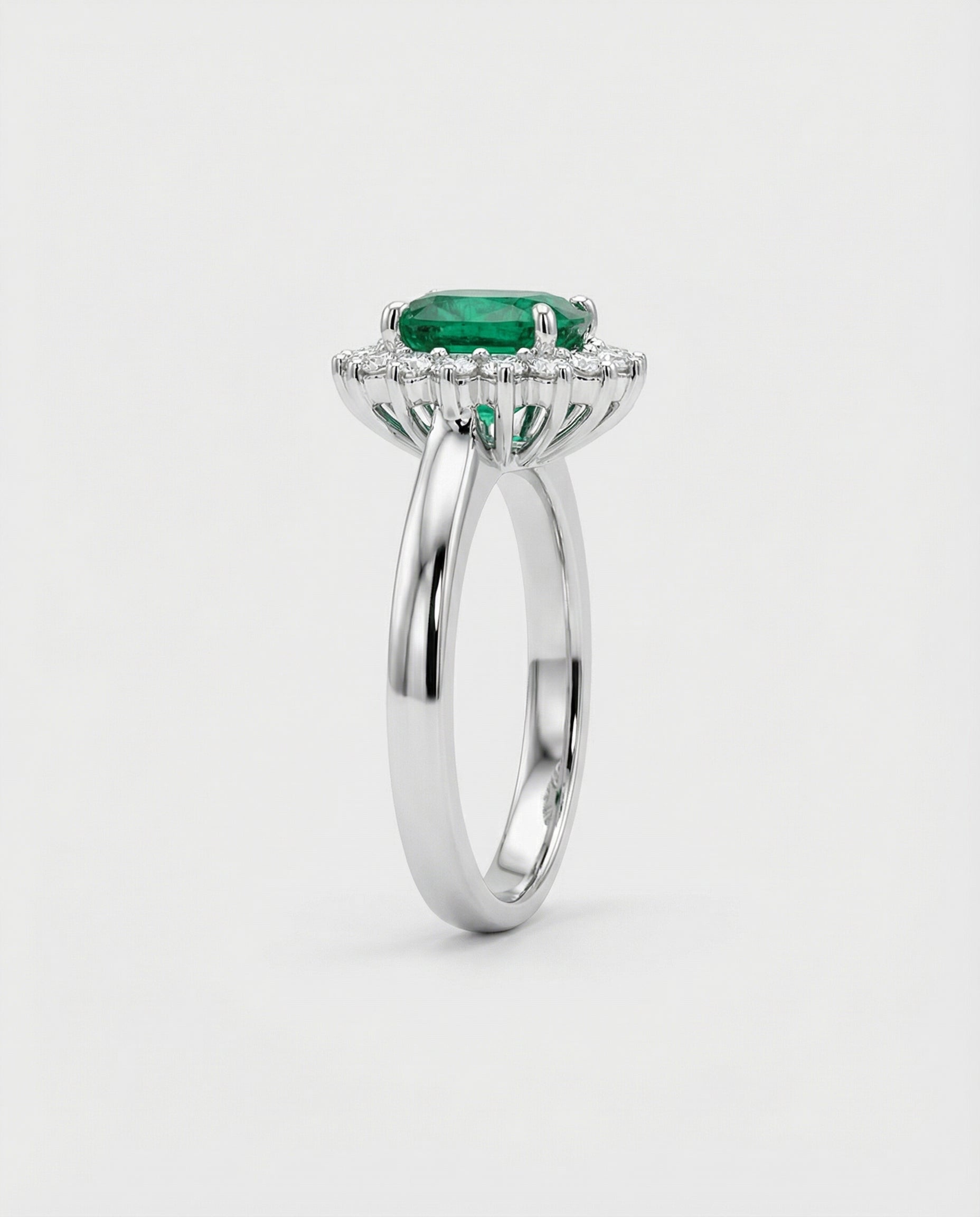 White gold ring with a green gemstone on a white background