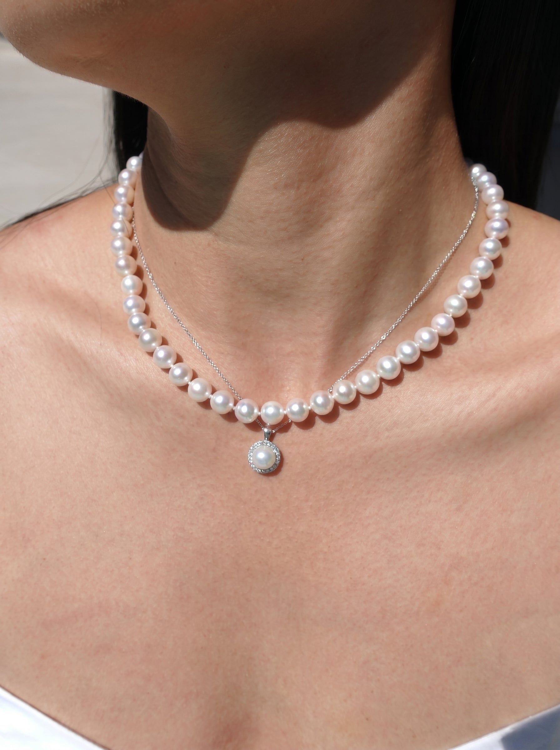 Pearl necklaces on a person's neck