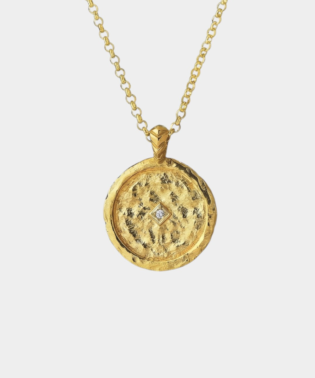 Gold necklace with a round pendant with a zircon on a white background