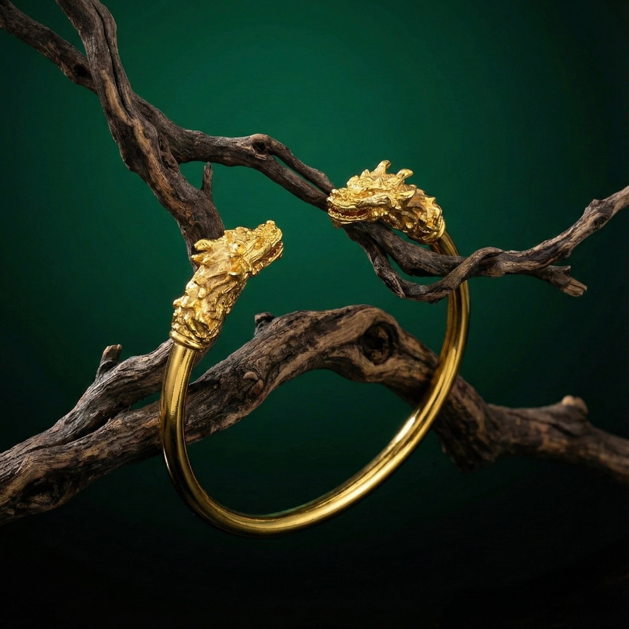 Gold bracelet with dragon head designs on a dark background