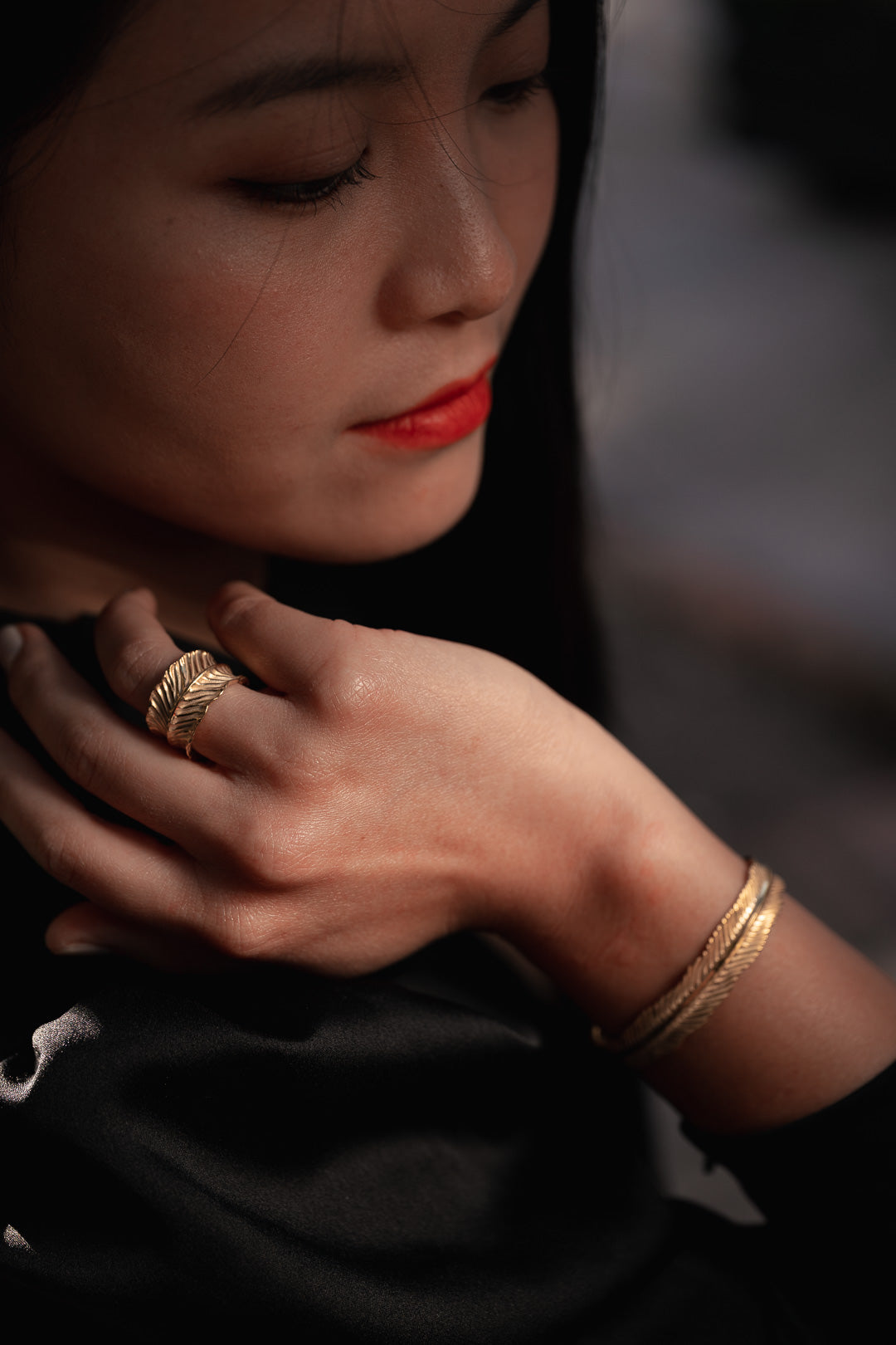 Close-up of a person wearing gold jewelry with a blurred background