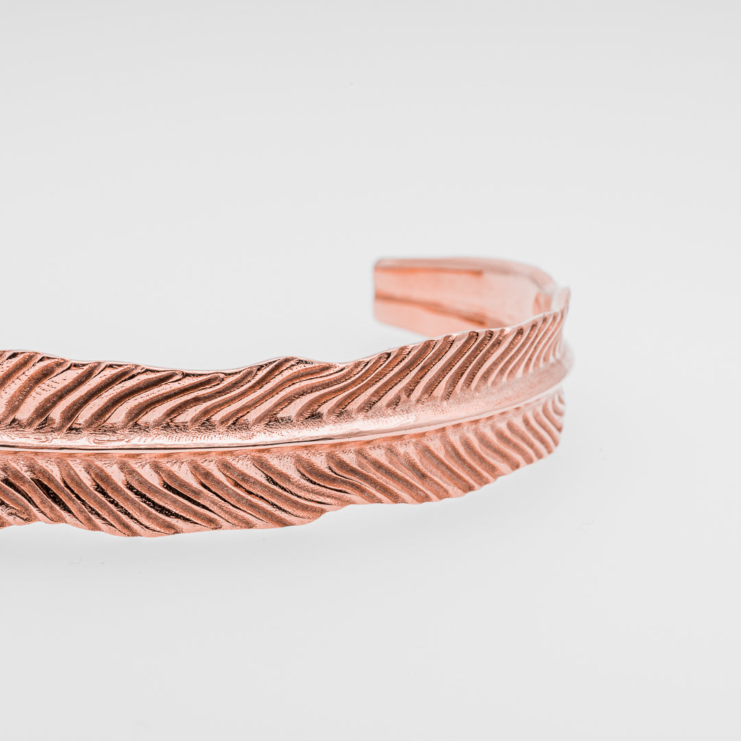 Rose gold textured bracelet on a light gray background