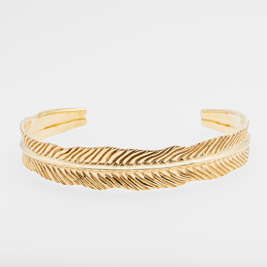 Gold dragon's eye bracelet on a light gray background