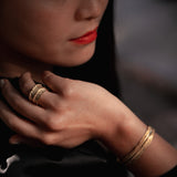 Close-up of a person wearing gold jewelry with a blurred background