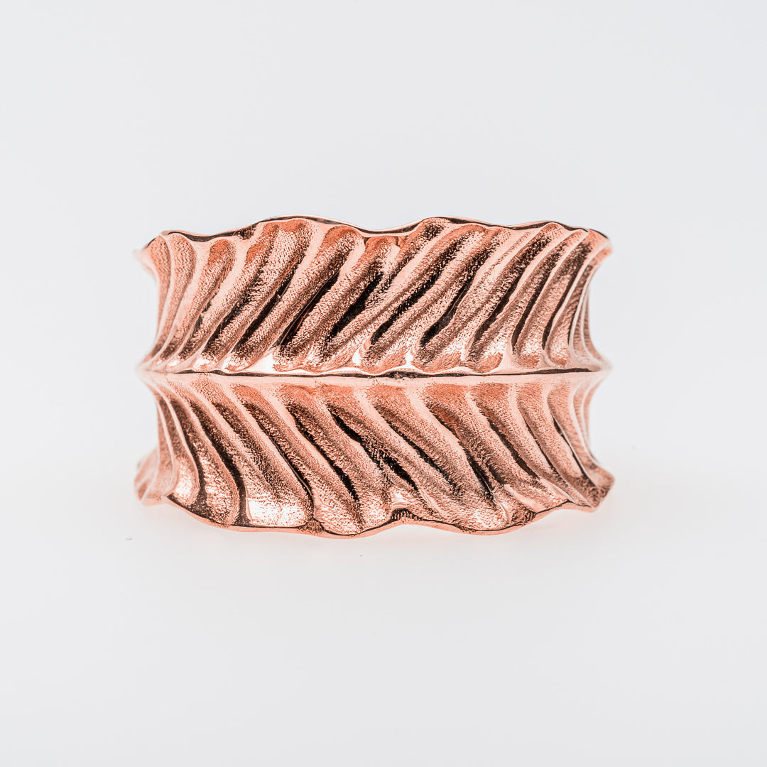 Rose gold ring with dragon's eye design on a light gray background