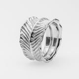 Silver ring with feather design on a light gray background