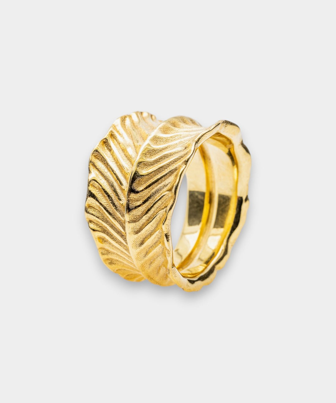 Gold ring with dragon's eye design on a light gray background