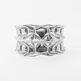 Silver ring with textured design on a white background