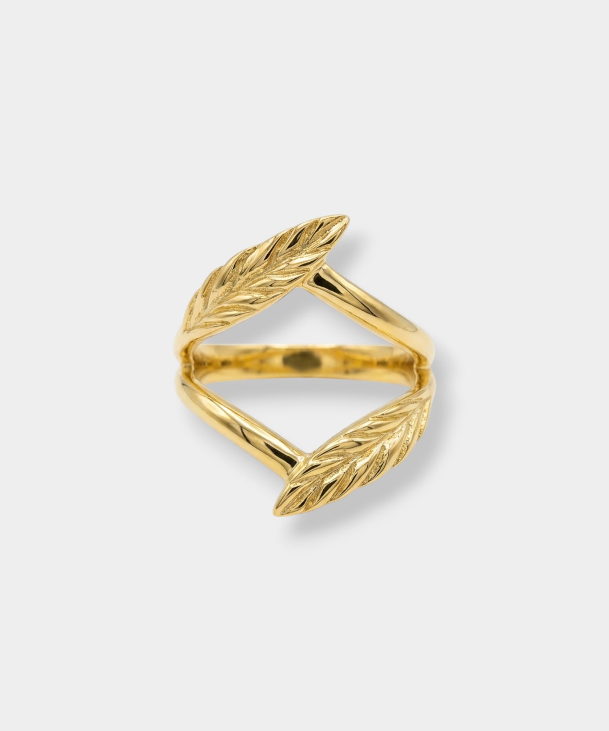 Gold leaf-shaped ring on a light gray background