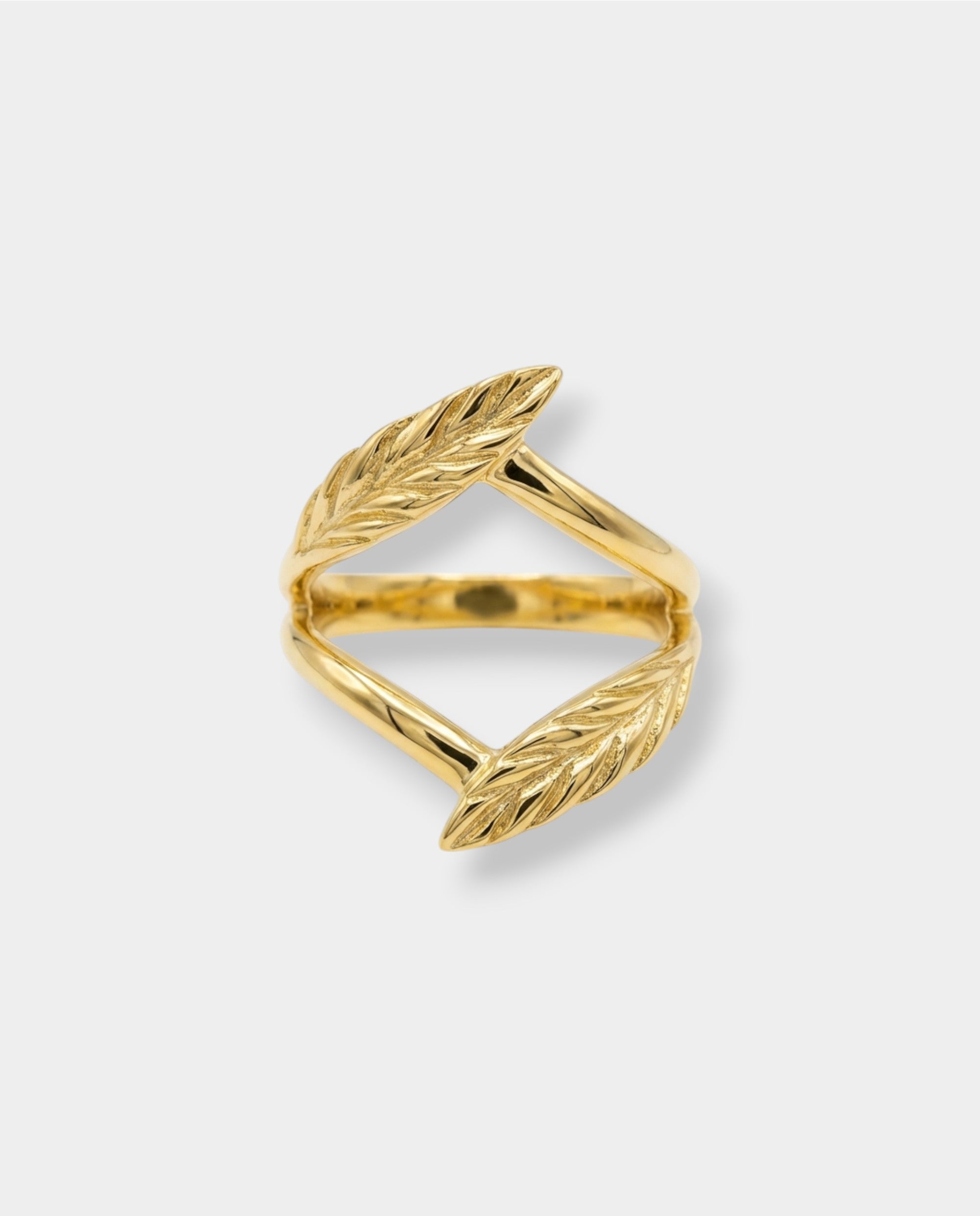 Gold leaf-shaped ring on a light gray background
