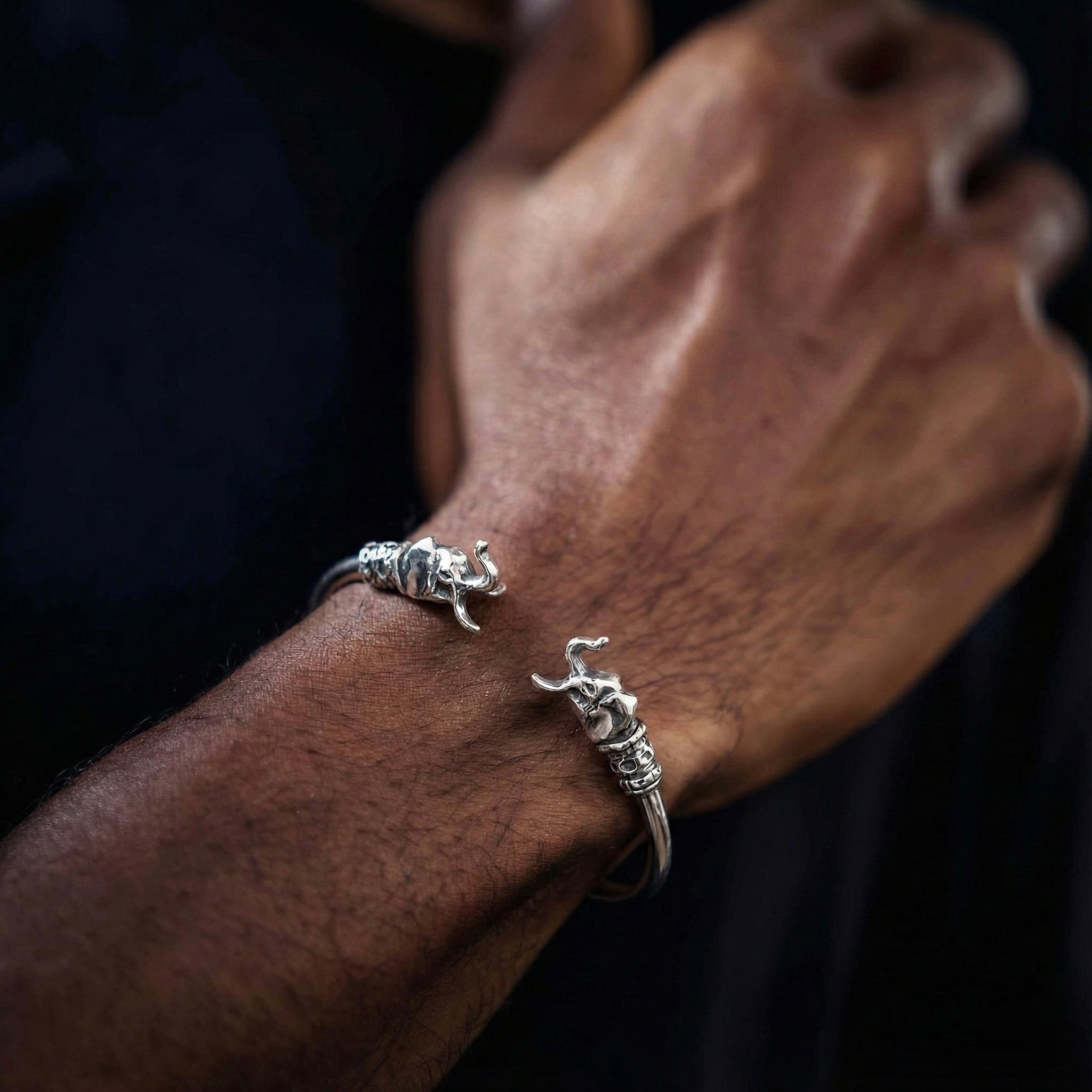 Silver ring with a unique elephant design on a wrist against a dark background