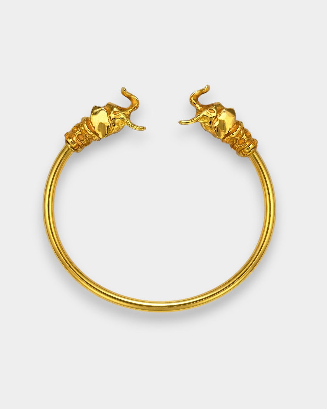 Gold elephant head hoop earrings on a white background