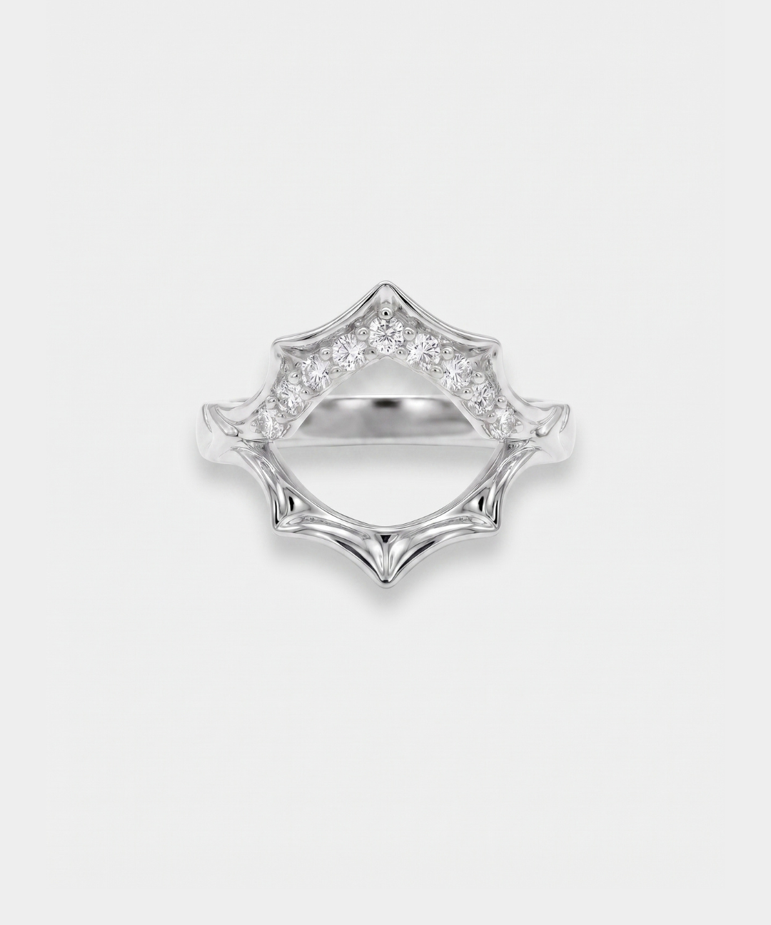 Silver sun-shaped ring with zircon accents on a light gray background