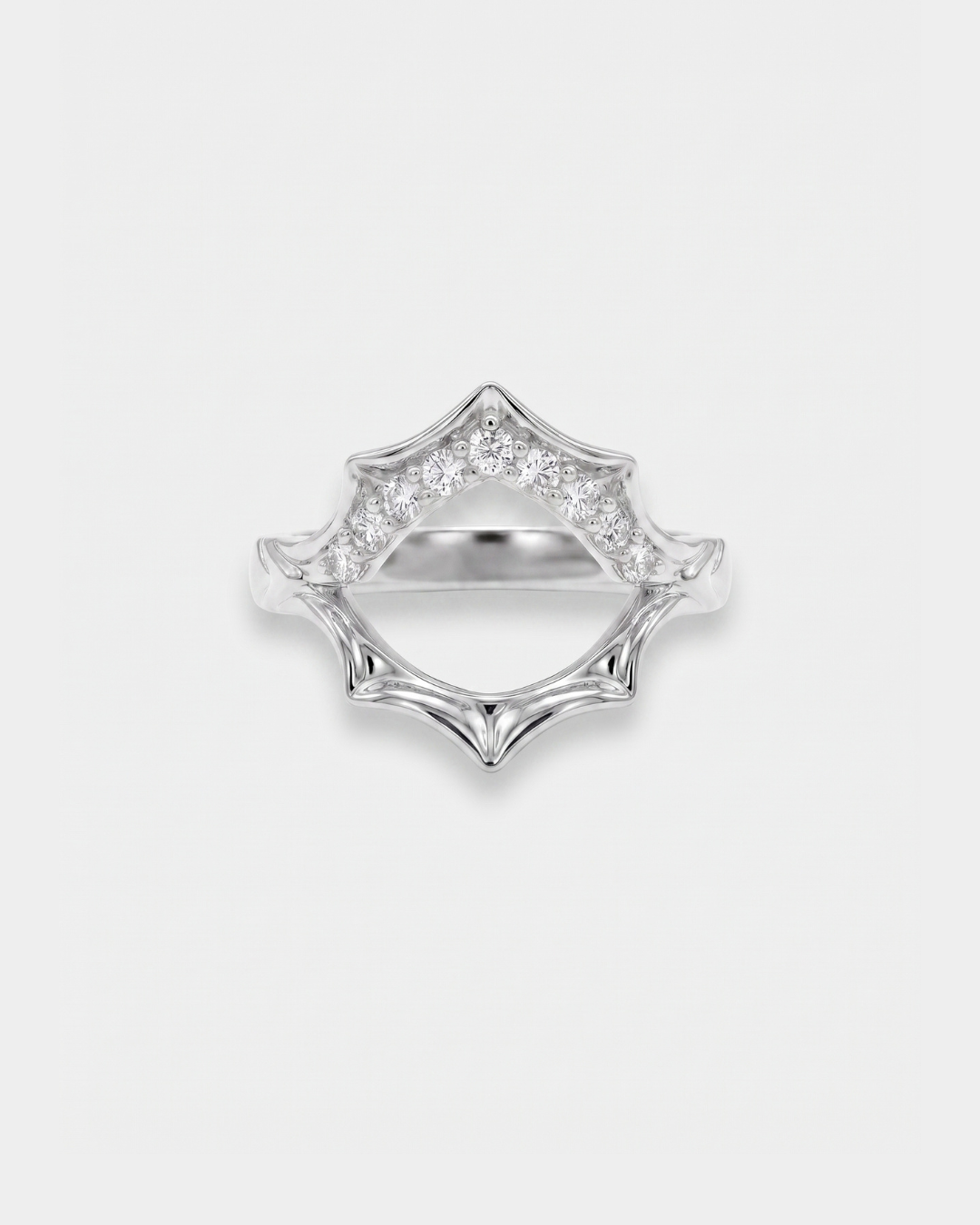 Silver sun-shaped ring with zircon accents on a light gray background